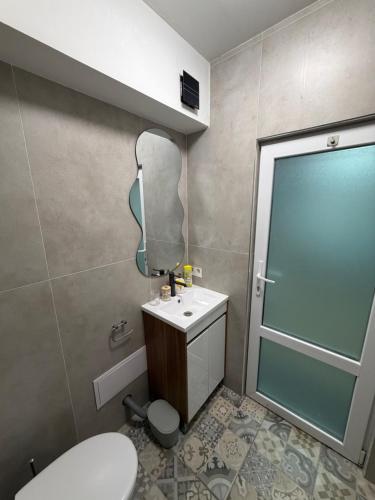 a bathroom with a toilet and a sink and a mirror at Nõma studio in Varna City