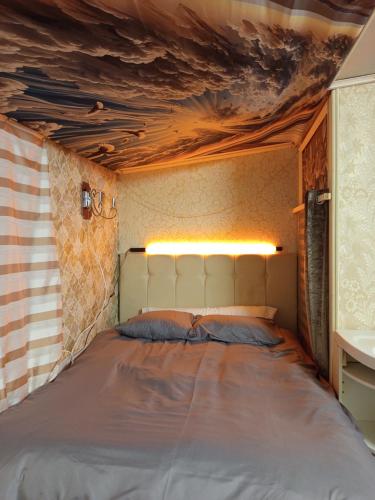 a bed in a room with a ceiling at Ofiss 24 in Riga