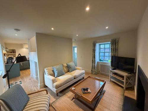 a living room with a couch and a tv at Gilchrist Square in Dornoch