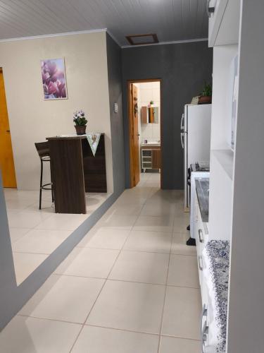 a kitchen with a white tile floor and a table at Casa com dois quartos cama de casal e vista panorâmica próximo a Gramado Serra Gaúcha in Igrejinha