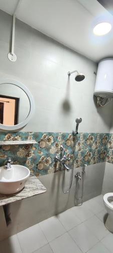 a bathroom with a sink and a toilet and a mirror at Minx guest house in Candolim
