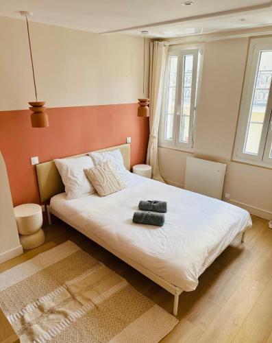 a bedroom with a bed with two towels on it at Les Bons Vivants - L'appartement in Trouville-sur-Mer