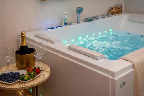 a hot tub with a bottle of wine and wine glasses at Villa Letto D'Alloro - Royal Dream in Conversano