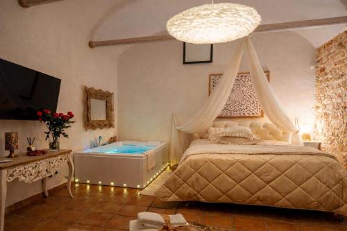 a bedroom with a bed and a tub in it at Villa Letto D'Alloro - Royal Dream in Conversano