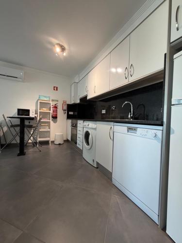 a kitchen with a washer and a sink and a dishwasher at Vela Terrace in Monte Gordo