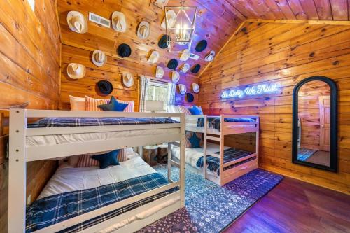 a cabin with bunk beds in a room with wooden walls at 15 min Dollywood, Game room, Hot tub, Shared pool, Pets Welcome in Pigeon Forge