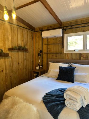 a bedroom with a large white bed with a window at Espaço Áurea 60km de Curitiba com Cesta de Café da manhã in Campina Grande do Sul