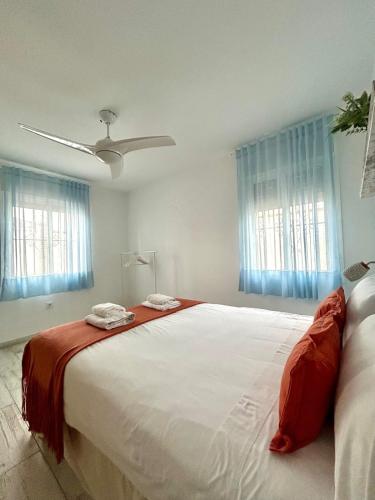 a bedroom with a large bed with red and white sheets at Hispalis villa de Espartinas in Espartinas