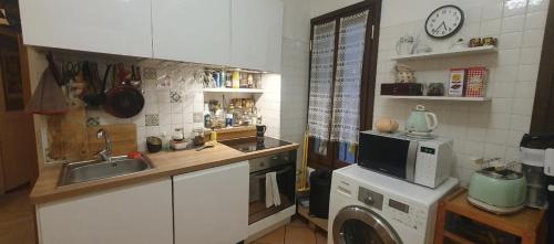 Shared Appartment with Kitten في نيس: مطبخ مع غسالة ملابس وميكروويف