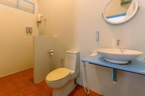 a bathroom with a sink and a toilet and a mirror at Slumber Resort Koh Chang in Ko Chang