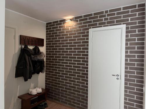 a room with a brick wall and a white door at Līgatne Forest View Apartament in Skalupji