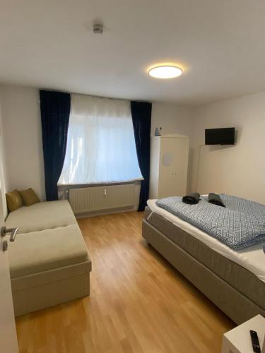 a bedroom with two beds and a couch and a window at Möwennest in Barsbek