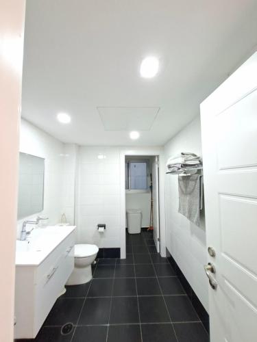 a white bathroom with a toilet and a sink at Shave Tsion Apartment in the center Ashdod in Ashdod