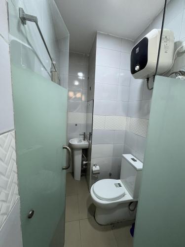a white bathroom with a toilet and a sink at Modern 2BR in Lekki Phase 1 in Lekki