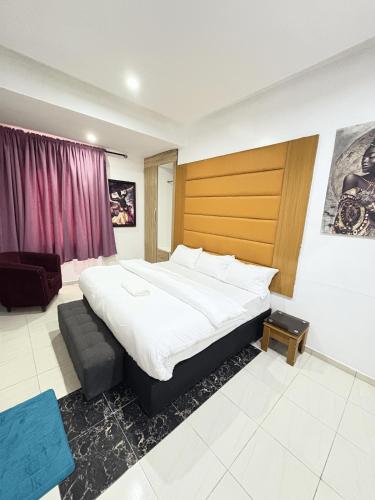 a bedroom with a large bed with a wooden headboard at Modern 2BR in Lekki Phase 1 in Lekki