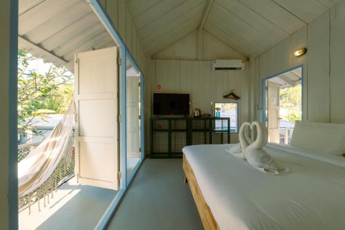 a bedroom with a bed and a balcony at Slumber Resort Koh Chang in Ko Chang