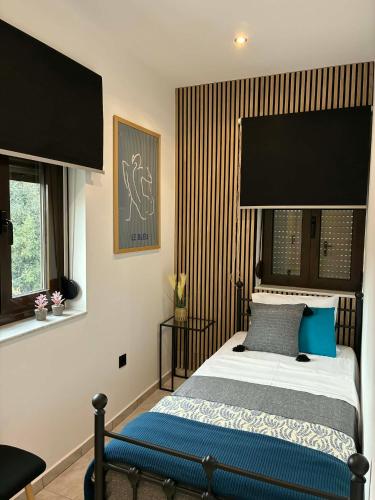 a bedroom with a bed with a large black headboard at Karadinos Apartment in Stílos