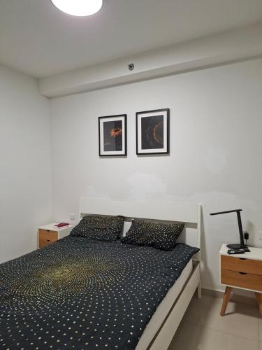 a bedroom with a bed and two pictures on the wall at Shave Tsion Apartment in the center Ashdod in Ashdod