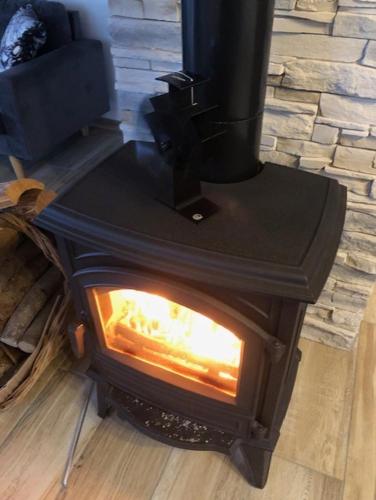 a black stove with a fire inside of it at Chalet Belfahy in Belfahy
