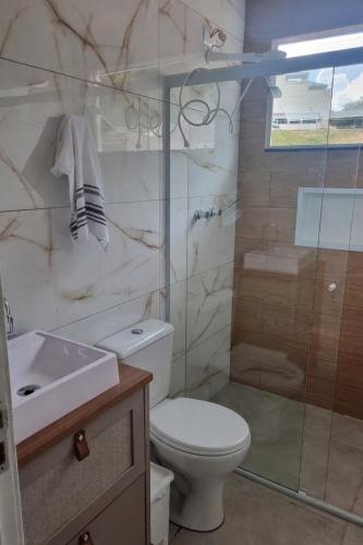 a bathroom with a toilet and a shower and a sink at Apartamento da Adriana in Itajubá