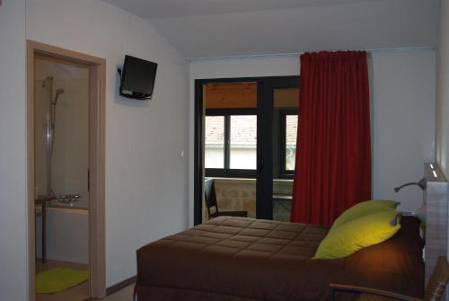 a bedroom with a bed with a yellow pillow and a window at Auberge de Marville in Marville