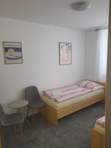 a bedroom with a bed and a table and a chair at Komárov Apartment 2 in Komárov