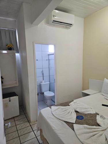 a room with two beds and a bathroom with a toilet at Hospedagem São Francisco in São Luís