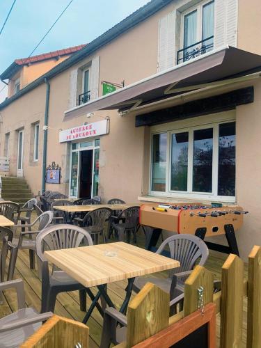 an outdoor patio with tables and chairs in front of a building at auberge de louroux in Louroux-de-Bouble