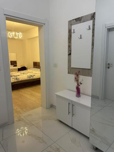 biały pokój z łóżkiem i lustrem w obiekcie E&M Apartman w mieście Struga