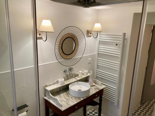 a bathroom with a sink and a mirror at La Maison Marguerite in Herrère