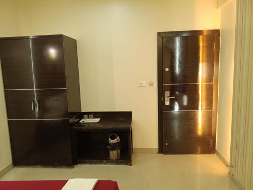 a bathroom with a refrigerator and a counter and a locker at Hotel Vaishnavi in Solapur