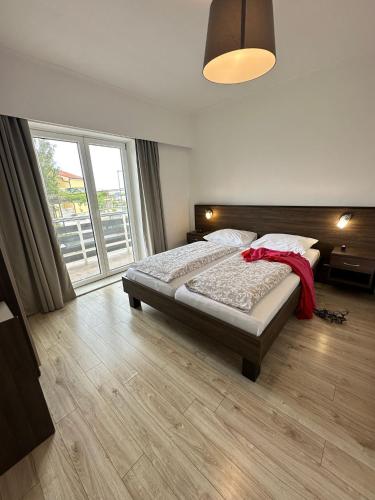 a bedroom with a bed and a large window at Apartments Božena in Vodice