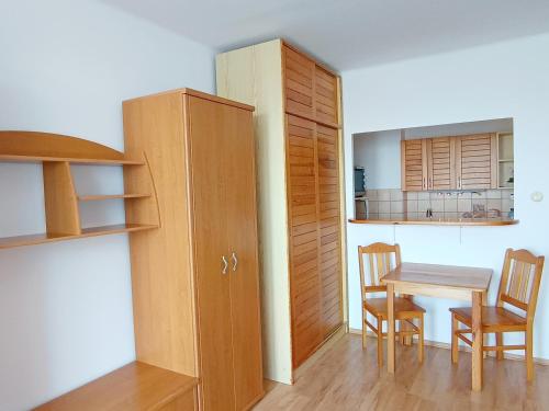 a room with a table and a cabinet and a table and chairs at Garzónka Trenčín in Trenčín