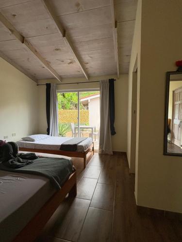 a bedroom with two beds and a large window at B&B Le Villette Las Lajas in Las Lajas
