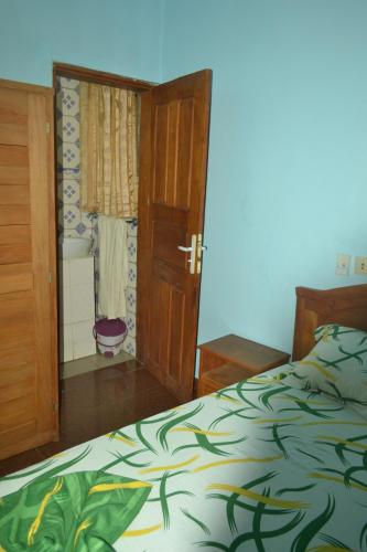 a bedroom with a bed and an open door at Résidence cosy proche chûtes de la Lobe in Kribi