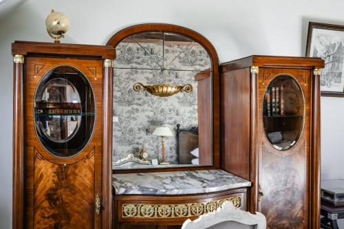 a room with a wooden cabinet and a mirror at Manoir La Ville Durand in Binic