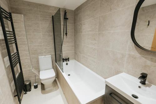 a bathroom with a tub and a toilet and a sink at SPINDLE COTTAGE - Riverside cottage on the edge of the Peak District in Holmfirth