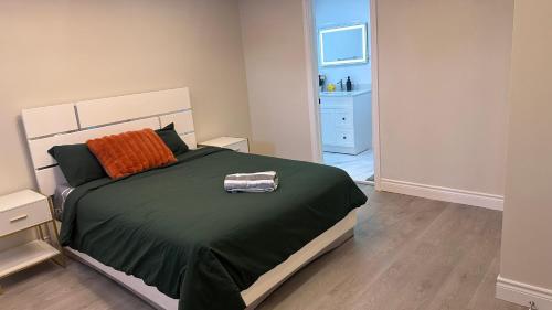 a bedroom with a large bed with an orange pillow at New and Stylish 3BR Private Basement Apartment with 3 Baths & Parking in Richmond Hill