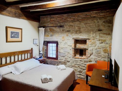 a bedroom with a bed and a stone wall at Hotel Convento San Roque in Balmaseda