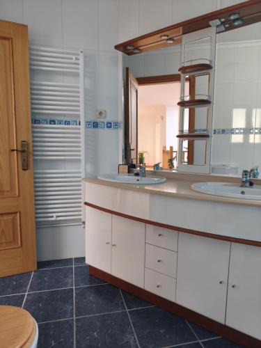 a bathroom with two sinks and a mirror at Zimão Garden House in Vila Real