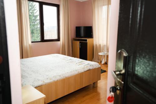 a small bedroom with a bed and a window at Casa Dorin Capacitate Autocar in Borşa