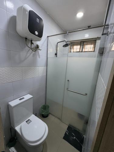 a small bathroom with a toilet and a shower at Modern 3BR in Lekki Phase 1 in Lekki