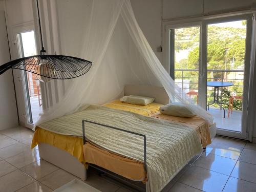 a bedroom with a bed with a mosquito net at Lagonisi Cottage - with spacious garden in Áyios Nikólaos
