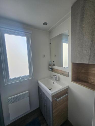 a white bathroom with a sink and a window at Chalet First Stage - Renesse in Renesse