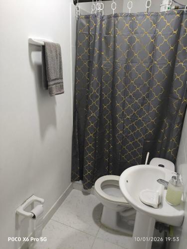 a bathroom with a toilet and a shower curtain at Habitación de Lujo para Pareja in Darién