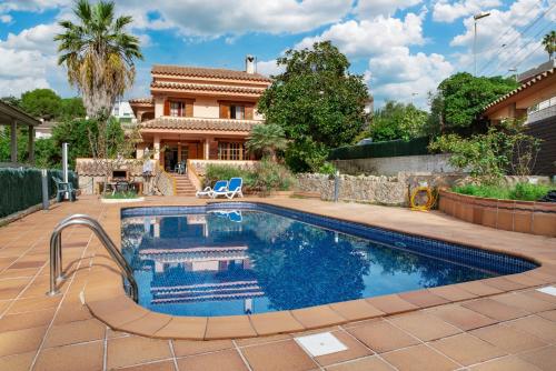 a swimming pool in front of a house at Villa Ficus in Lloret de Mar