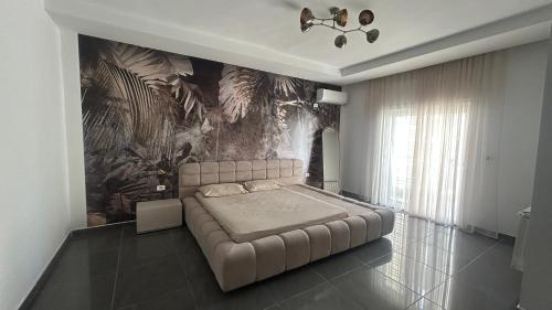 a bedroom with a bed and a wall with a mural at Da Dora in Dar el Haj Ahmed Souid
