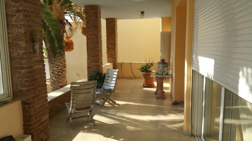 um pátio com cadeiras e uma mesa num edifício em Surf House em Artemida