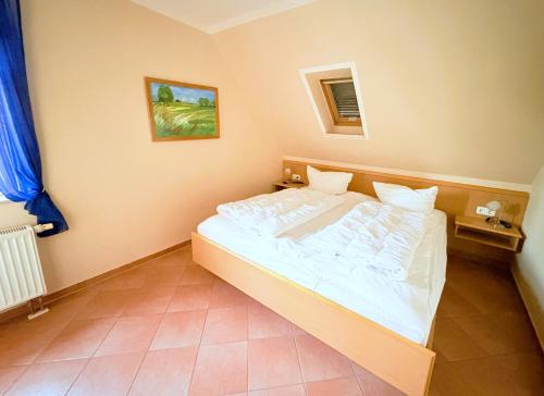 a bedroom with a white bed in a room at Fewo Lavendel - mit Dachterrasse, Hund ist willkommen in Mariendorf