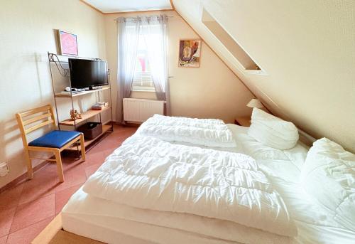 a bedroom with a white bed and a tv at Ferienwohnung Flieder - ruhig und tierfreundlich in Mariendorf